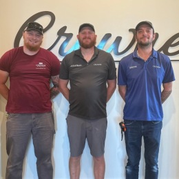 three men smiling at a camera