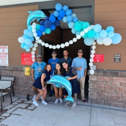 people standing under a balloon arch